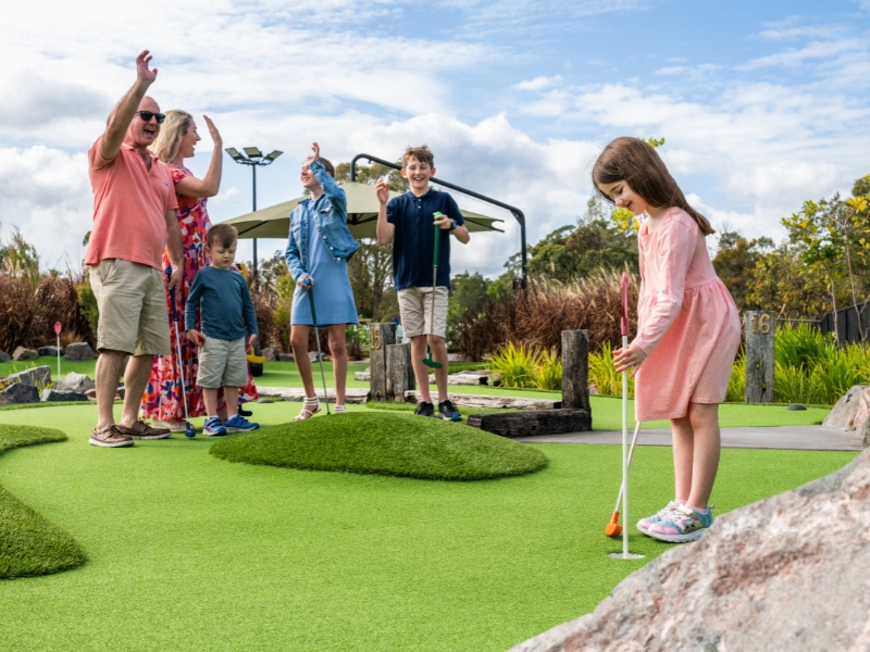 family playing noosa mini golf